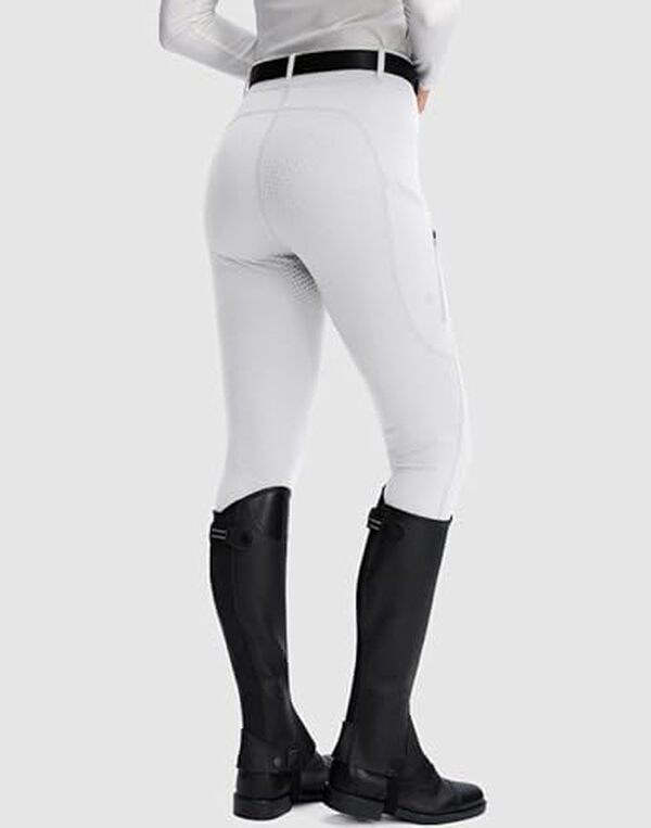 Découvrez le pantalon d'équitation Santiny pour femme : une coupe ajustée taille XS avec des poches zippées pratiques. Alliez style et fonctionnalité pour vos séances d'équitation.